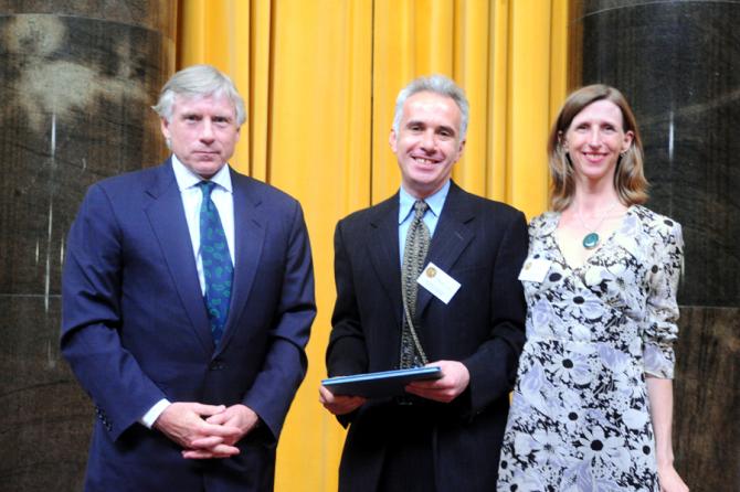 Lee C. Bollinger (left) presents the 2011 Pulitzer Prize in International Reporting to Clifford J. Levy and Ellen Barry of The New York Times.