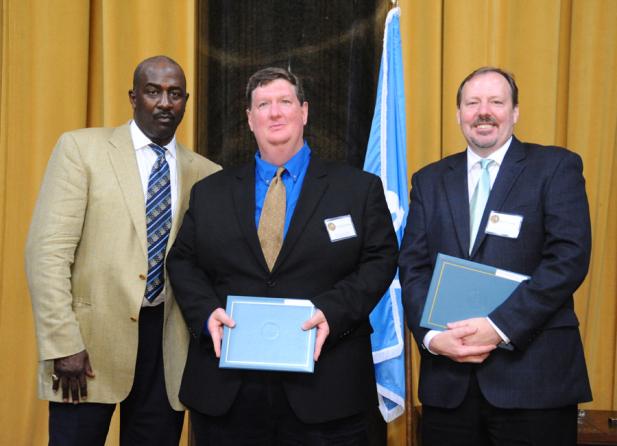 Gregory Moore (left) presents the 2012 Pulitzer Prize in Investigative Reporting to Michael J. Berens (center) and Ken Armstrong of The Seattle Times.
