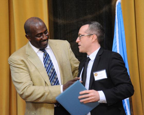 Gregory Moore (left) presents the 2012 Pulitzer Prize in Feature Writing to Eli Sanders of The Stranger, a Seattle weekly.