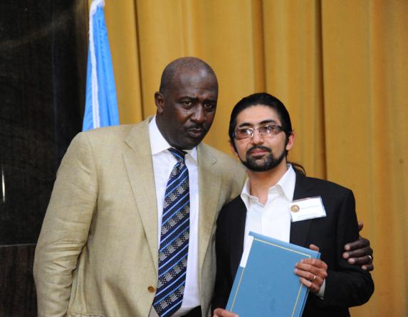 Gregory Moore (left) presents the 2012 Pulitzer Prize in Breaking News Photography to Massoud Hossaini of Agence France-Presse.